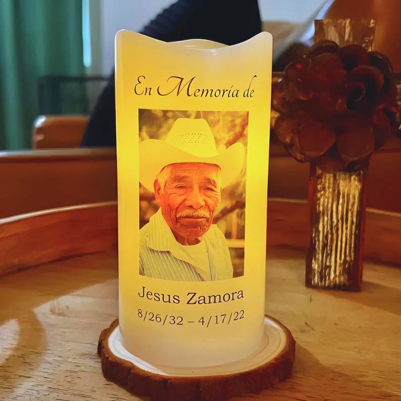 Real Etsy listing photograph of a glowing personalized memorial LED candle with a photograph, name and dates